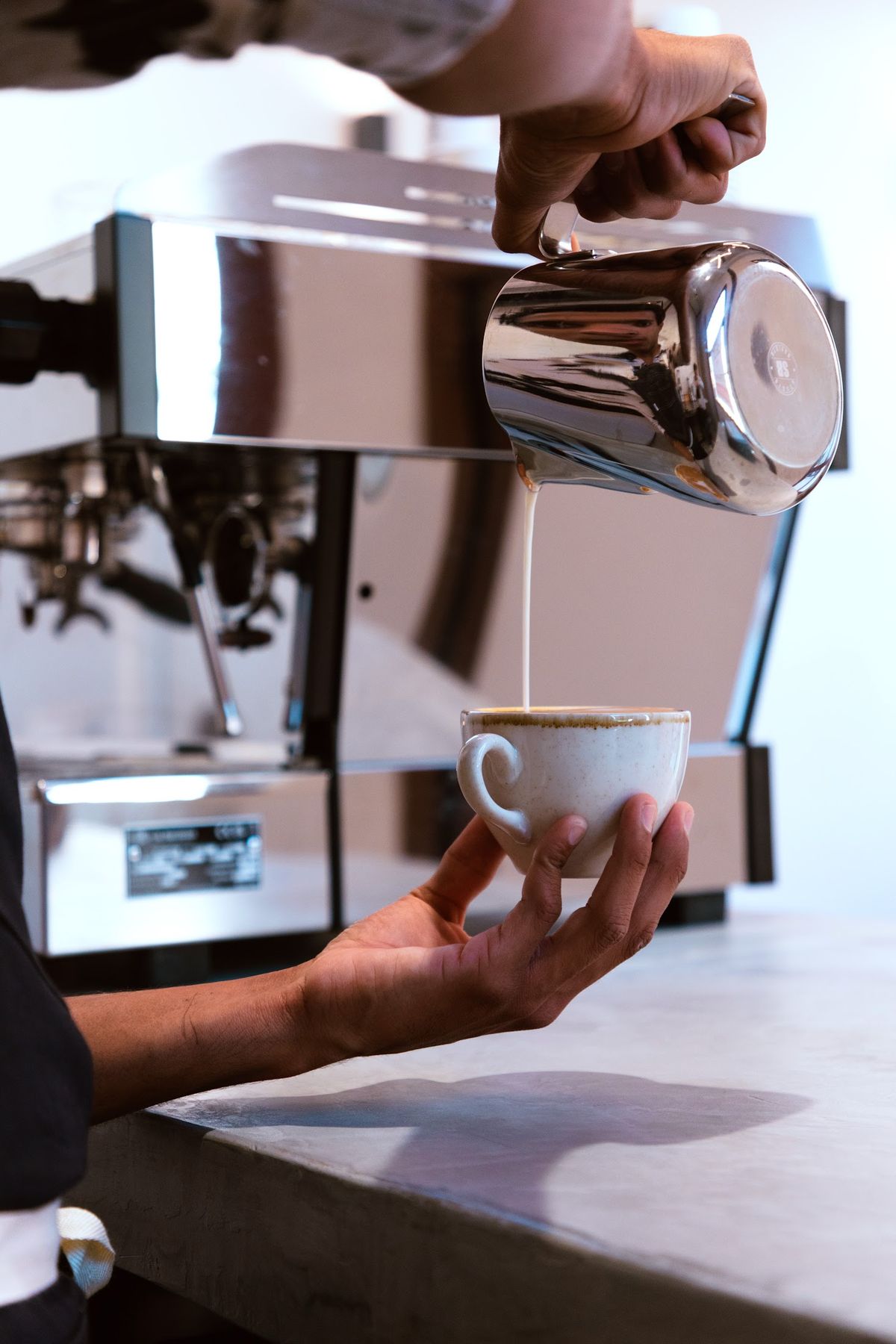 Barista sirviendo leche en una taza